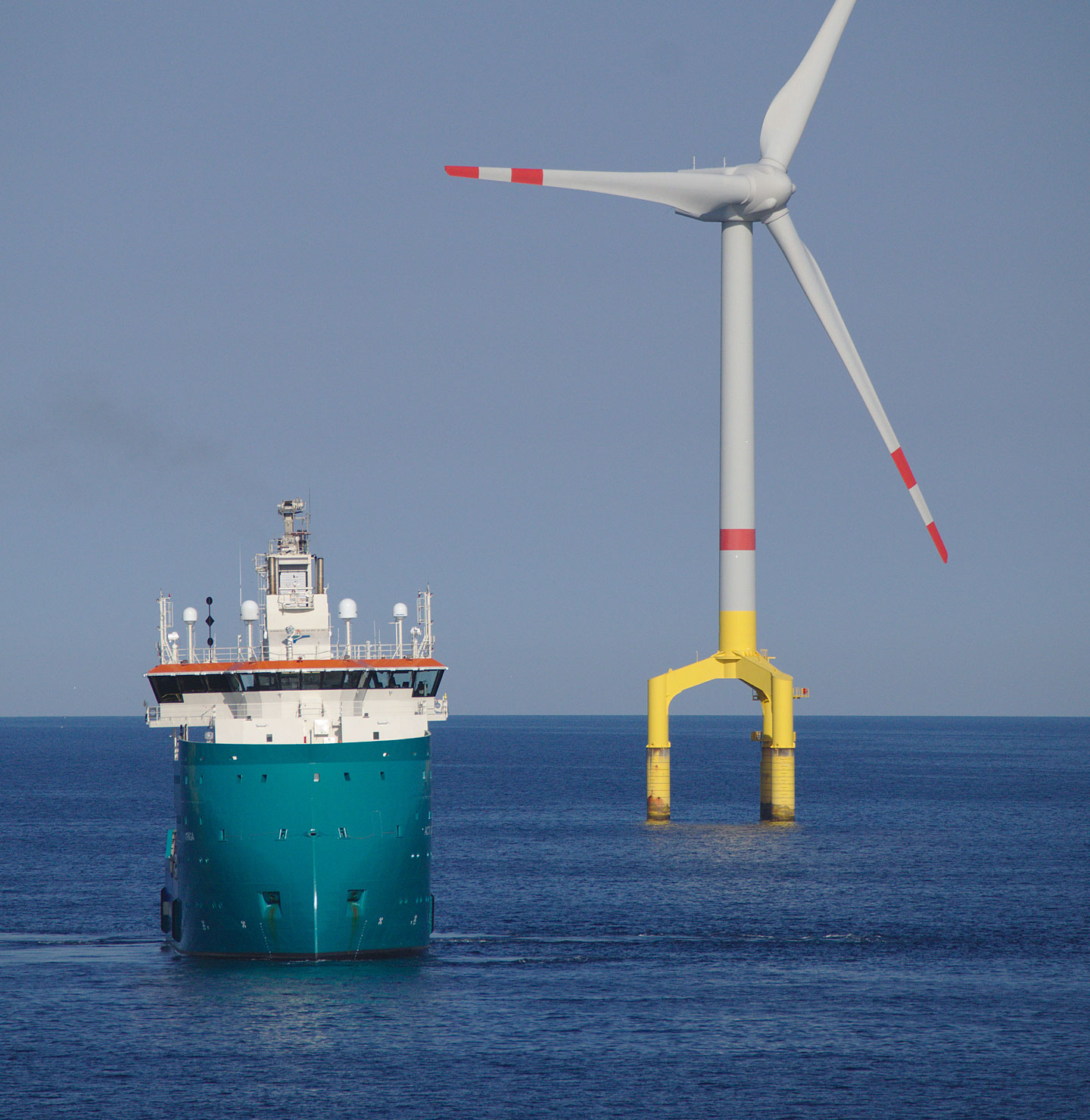 Ship next to a wind turbine.